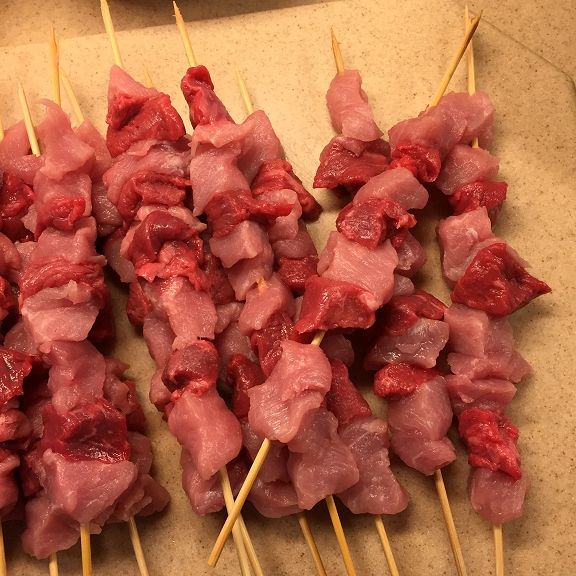 several skewers of meat sitting on top of a table