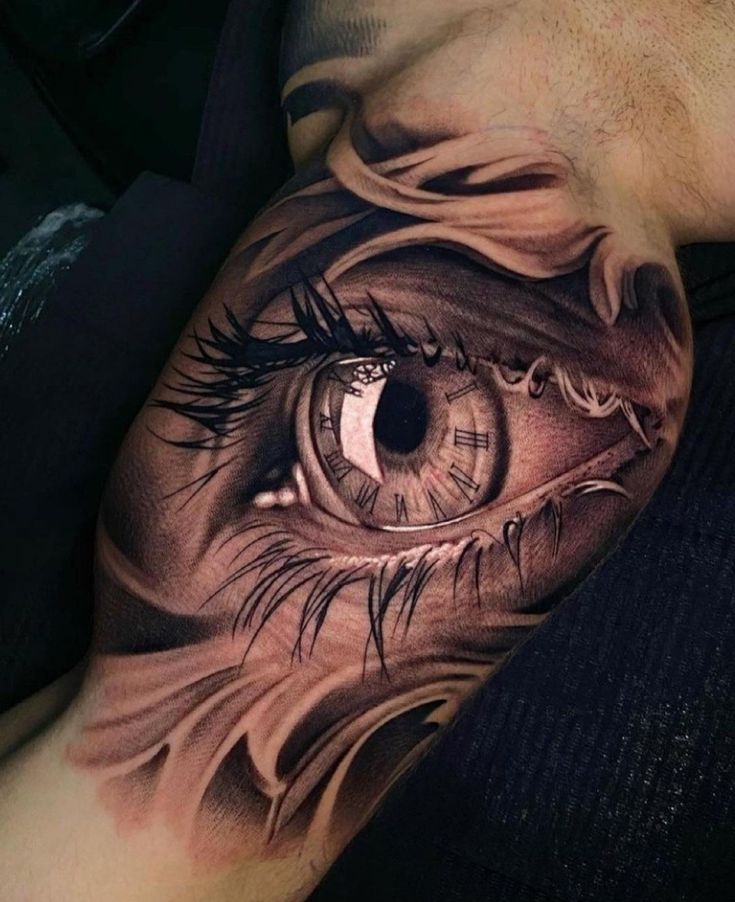 an eye tattoo on the side of a man's leg, with long eyelashes