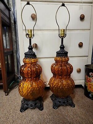 two orange glass lamps sitting next to each other on top of a table in front of a dresser