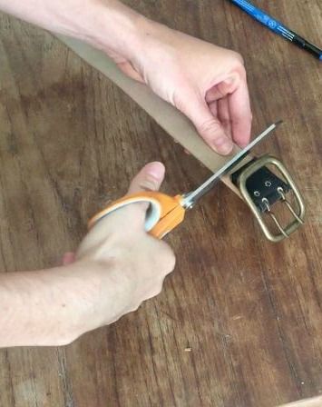 a person cutting paper with scissors on a wooden table