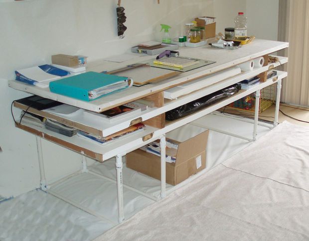 an office desk with lots of clutter sitting on it's top and bottom shelves