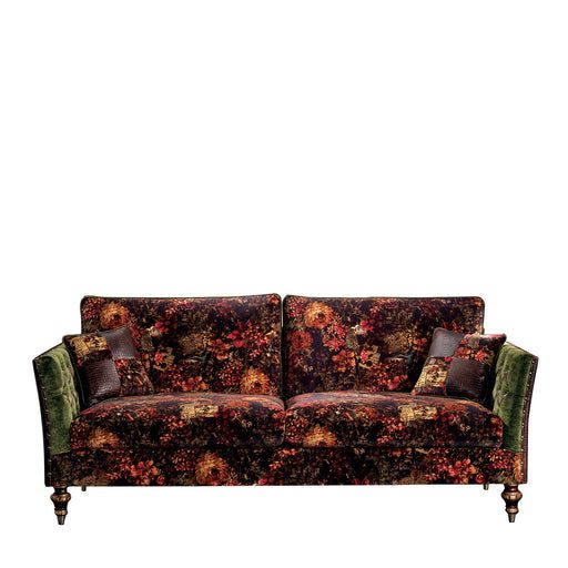 a couch that is sitting in front of a white wall with a flower pattern on it