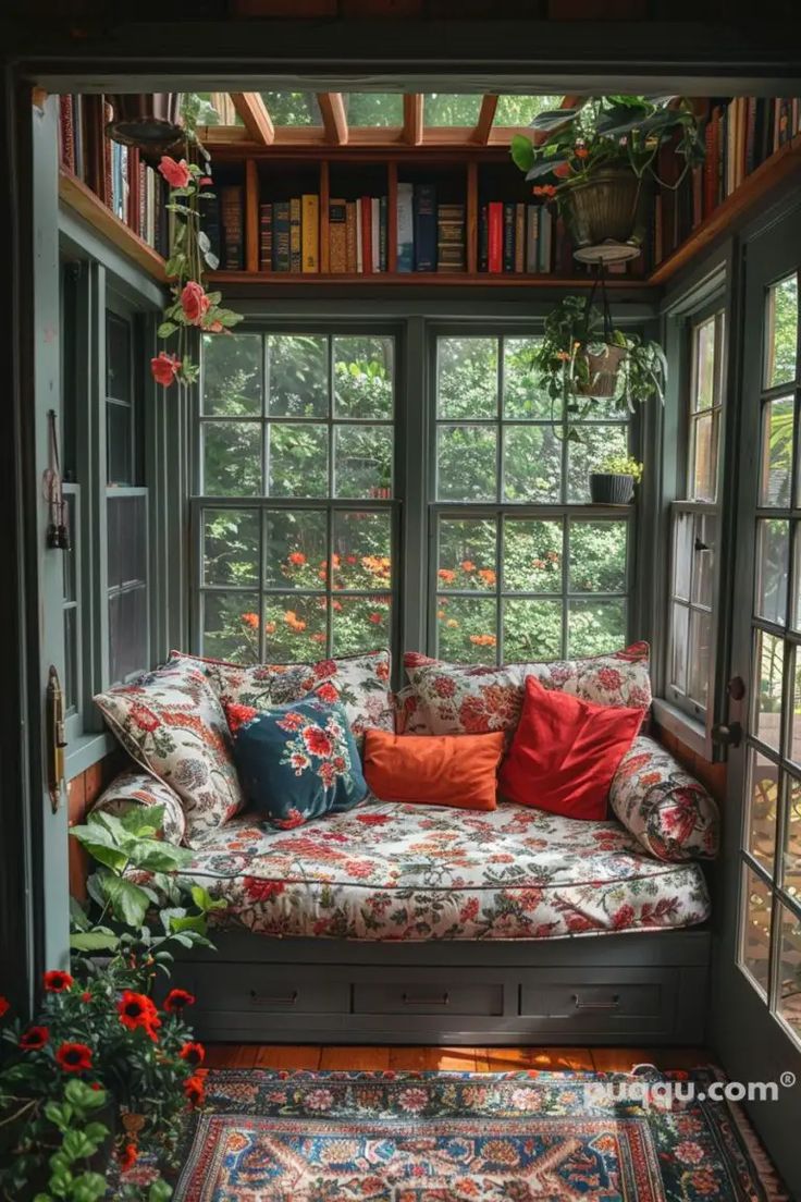 a couch sitting in front of a window filled with lots of plants and bookshelves