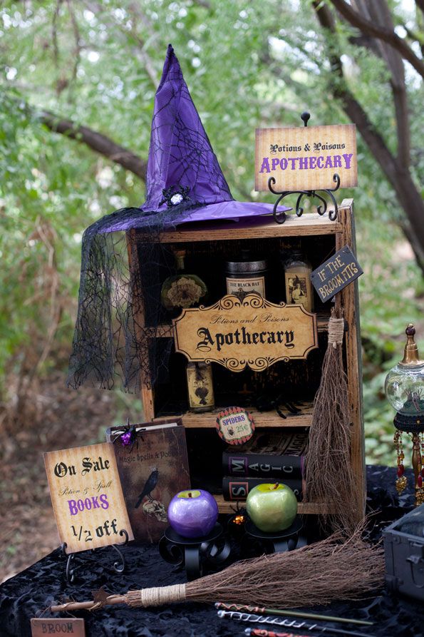 a table topped with lots of halloween decorations and witches hats on top of each shelf