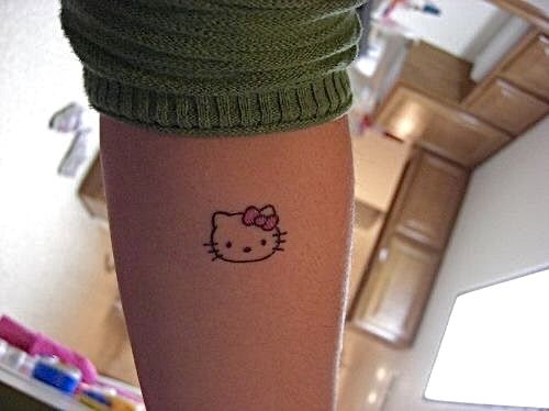 a person with a hello kitty tattoo on their arm