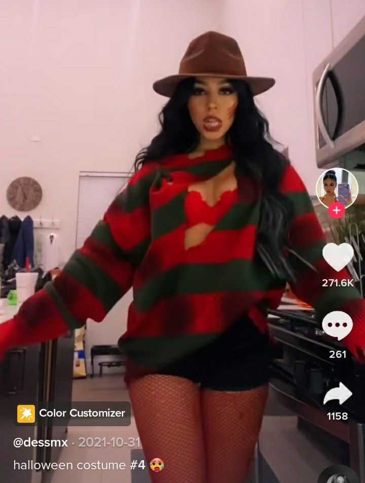 a woman wearing a red and green striped sweater with black fishnet stockings, holding her hands out to the side