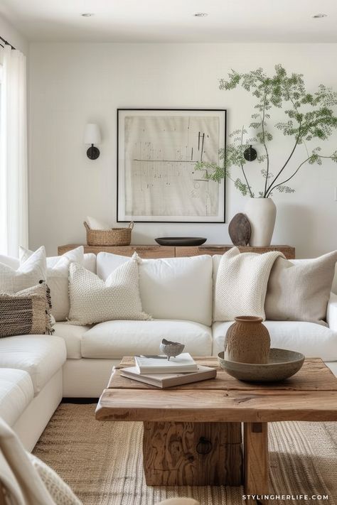 a living room filled with white furniture and pillows