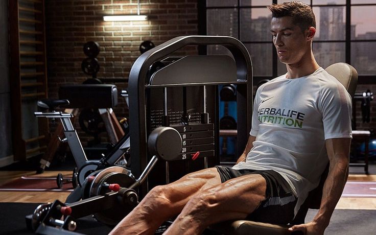 a man sitting on top of a machine in a gym