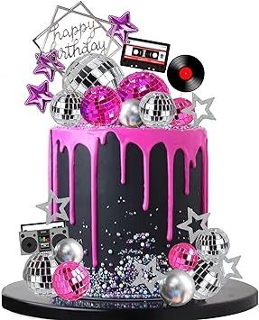 a pink and black birthday cake with disco balls, stars and cassettes on it