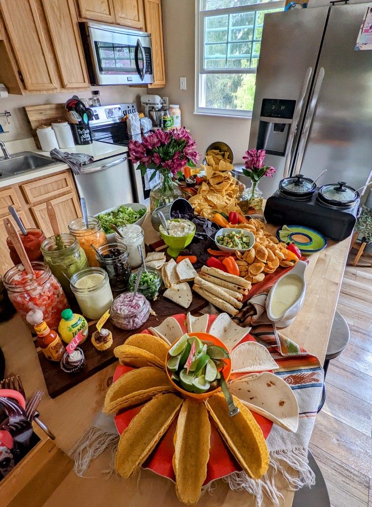 a table filled with lots of food on top of a kitchen counter