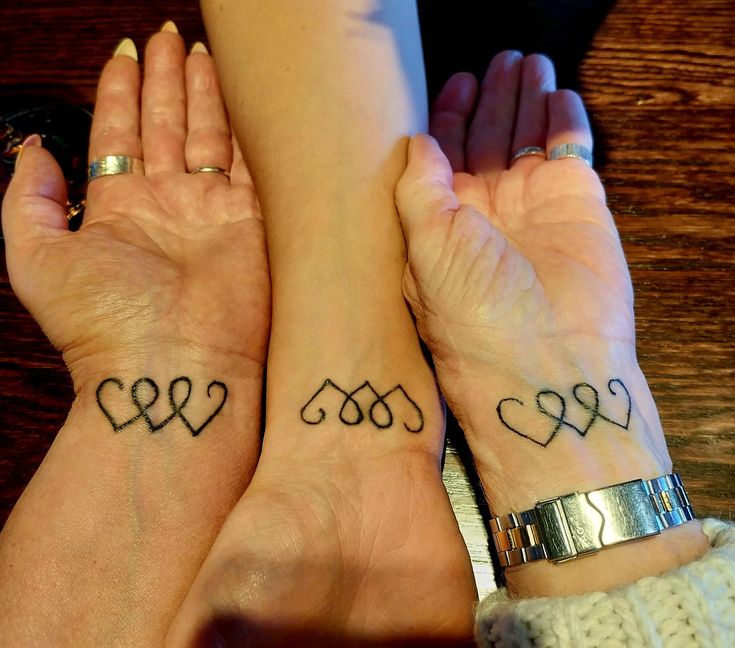 two women with matching tattoos on their hands