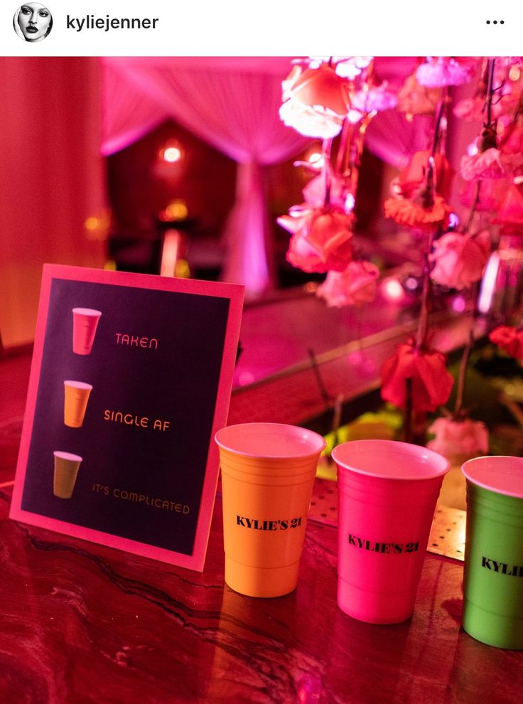 there are three cups on the table and one has a sign in front of it