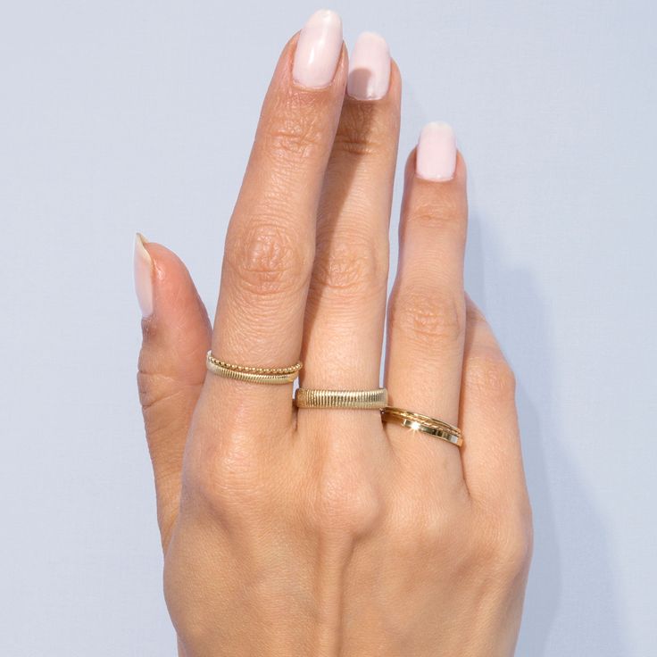 a woman's hand with two gold rings on it