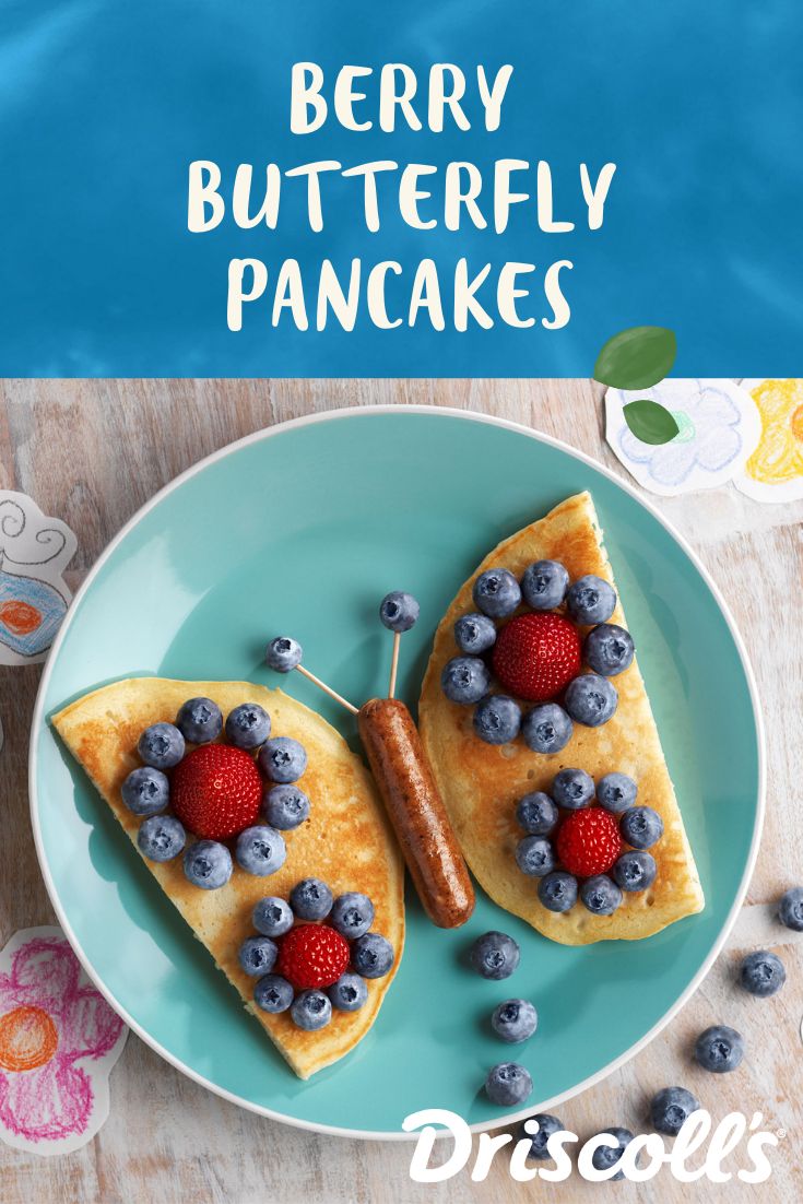 two pancakes with berries and blueberries are on a plate