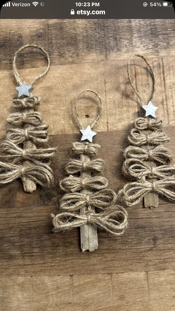 three small christmas trees made out of twine and rope on top of a wooden table