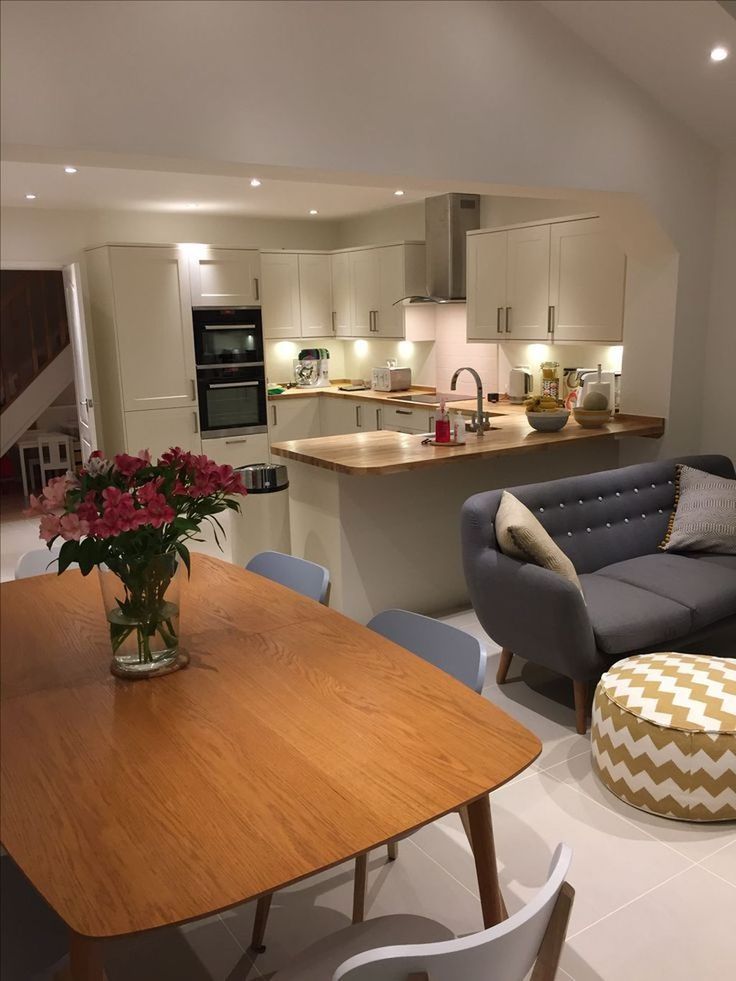 a living room and kitchen area with couches, tables, chairs and an oven