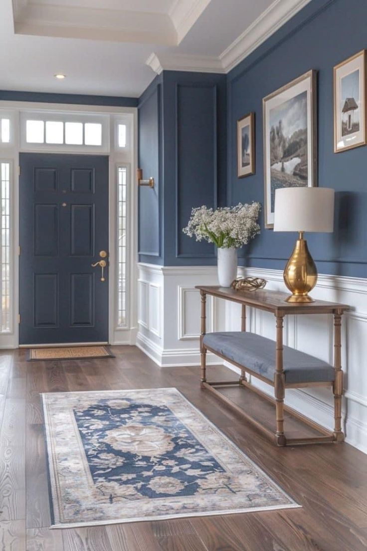 a hallway with blue walls and white trim, wood flooring and a rug on the floor