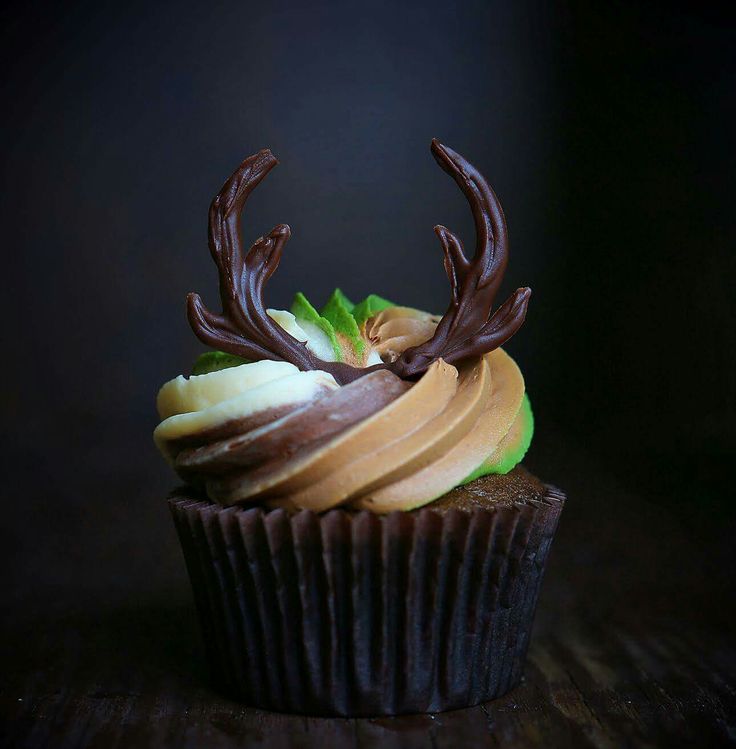 a cupcake with chocolate icing, apples and antlers on it's top