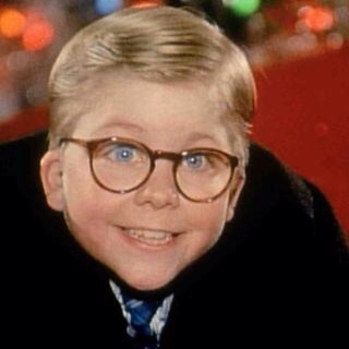 a young boy wearing glasses and a black coat with a blue tie on his neck