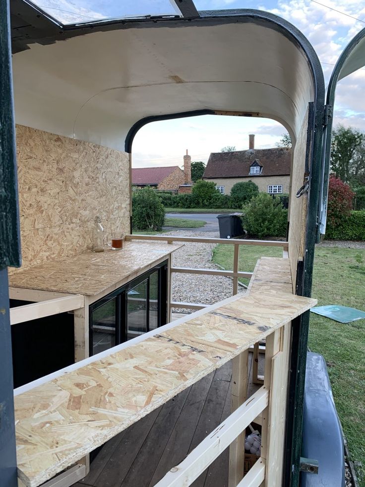 the inside of a mobile home with wood and plywood on the outside, looking into the kitchen area