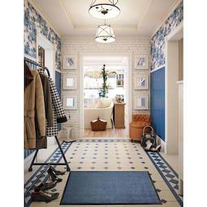 a hallway with blue and white tiles on the floor, rugs and coat racks