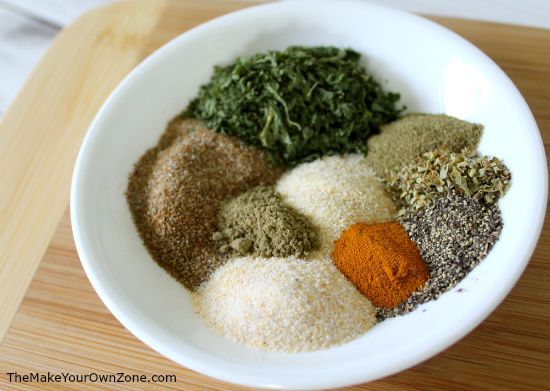 a white bowl filled with spices on top of a wooden table