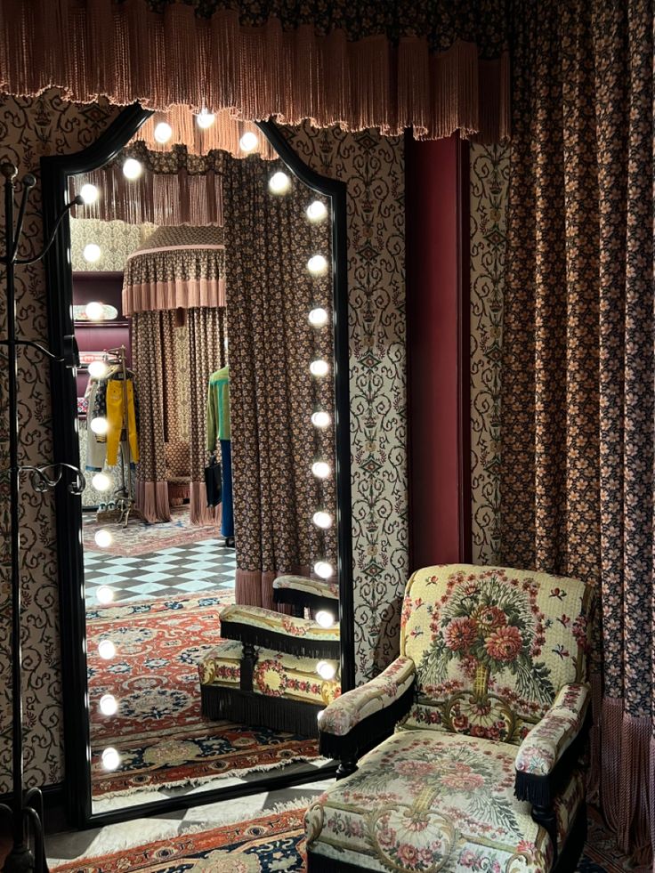 a chair sitting in front of a large mirror with lights on it's sides