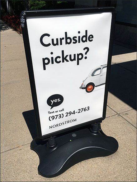 a sign on the sidewalk advertising curbside pickup