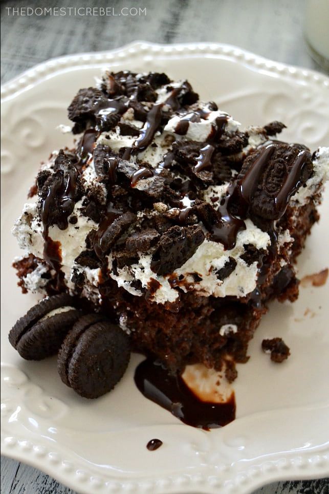 a piece of cake with oreo cookies and cream on it sitting on a white plate