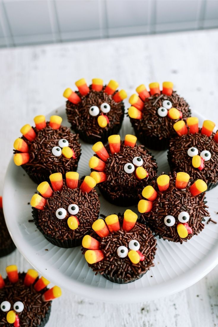 cupcakes decorated like turkeys with chocolate frosting and sprinkles