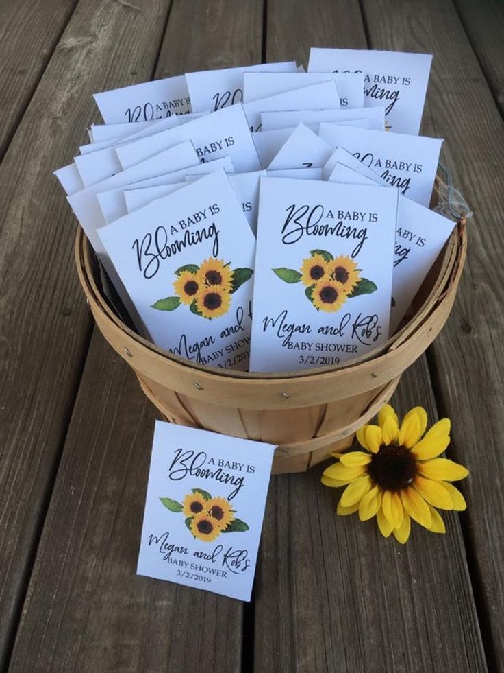 a basket filled with lots of cards next to a sunflower on top of a wooden table