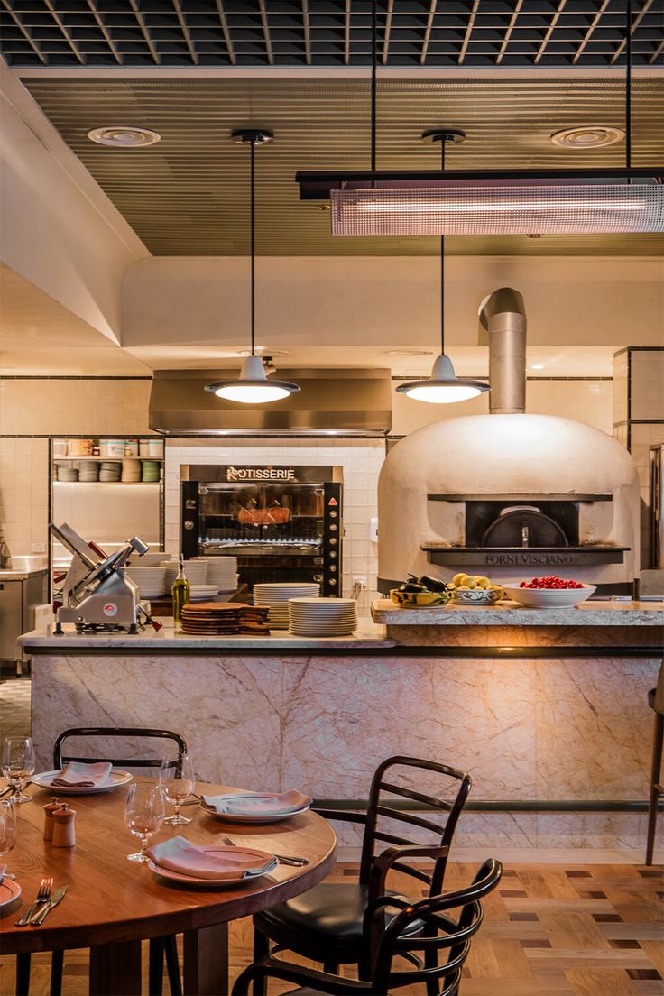 a kitchen filled with lots of counter space next to a stove top oven and dining room table