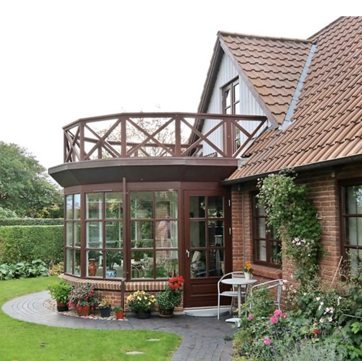 a house with lots of plants and flowers in the front yard