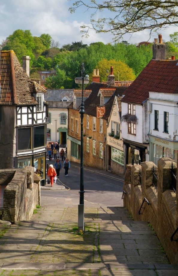 people are walking down the street in an old town