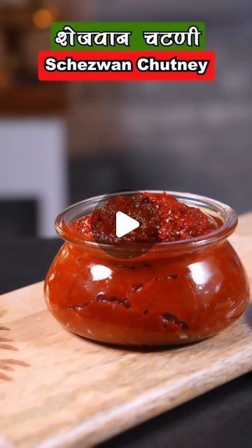 a small bowl filled with sauce on top of a wooden cutting board