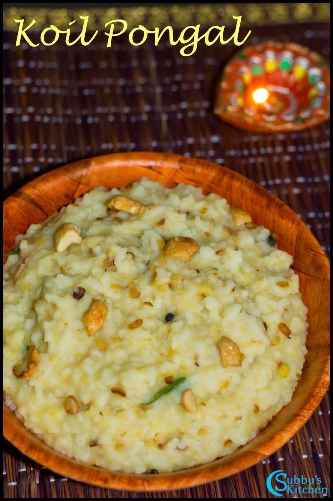 a wooden bowl filled with rice and nuts on top of a table next to a candle