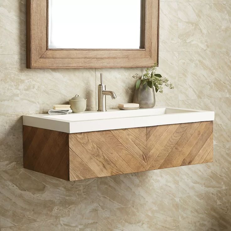 a bathroom sink sitting under a mirror next to a wall mounted faucet with a wooden frame