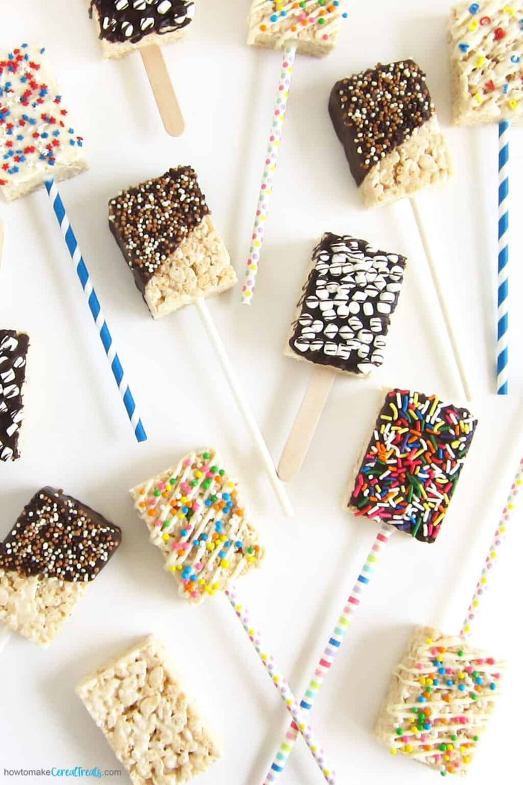 marshmallows and sprinkles are arranged on sticks