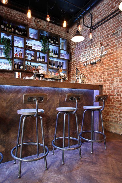 three bar stools in front of a brick wall