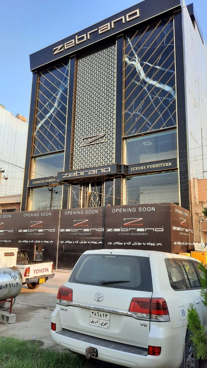 a white car parked in front of a tall building