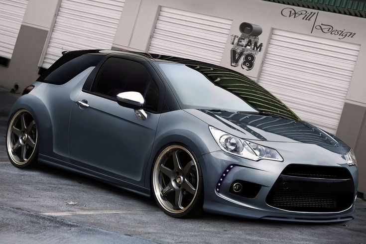 a grey sports car parked in front of a garage