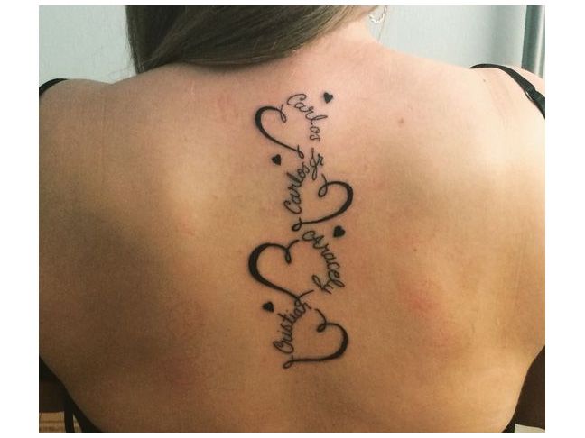 the back of a woman's neck with two hearts and an inscription on it