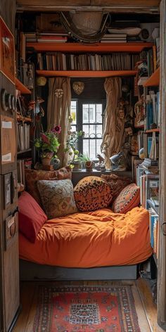 an orange bed sitting in the middle of a room with lots of bookshelves