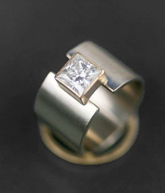 an engagement ring with a princess cut diamond set in 18k yellow gold and white gold