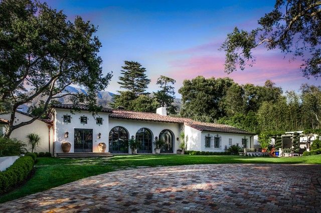 a white house surrounded by trees and grass