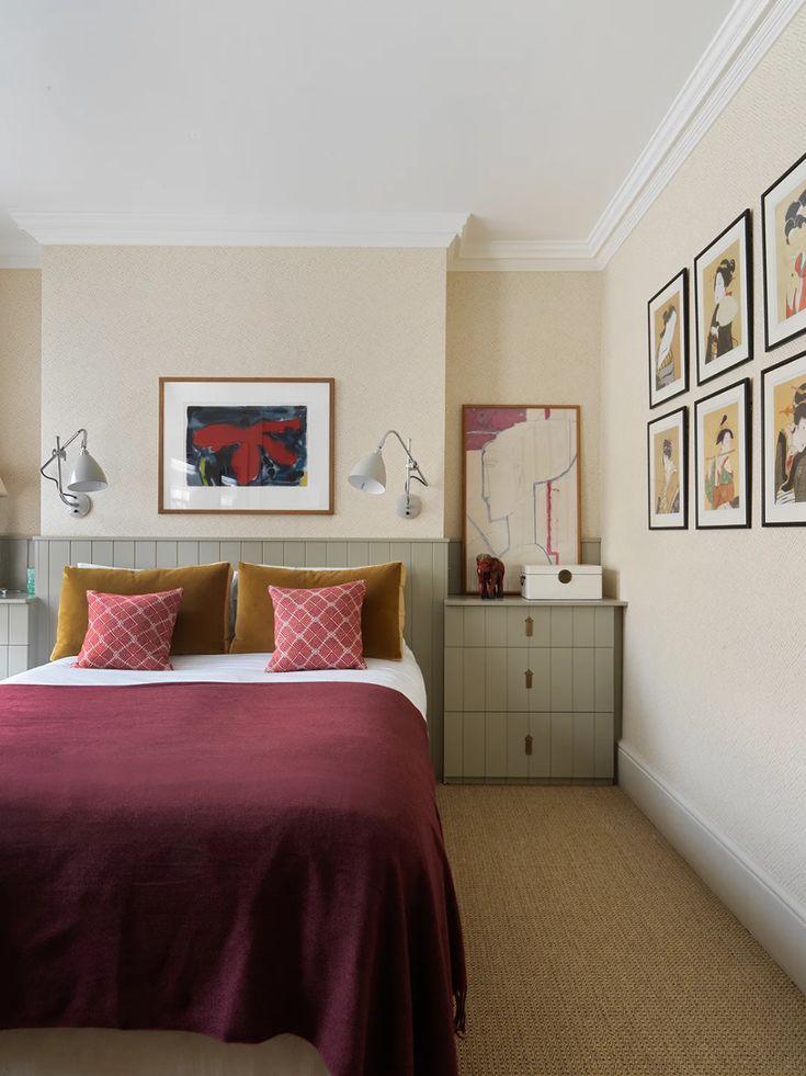 a bed sitting in a bedroom next to two pictures on the side of a wall