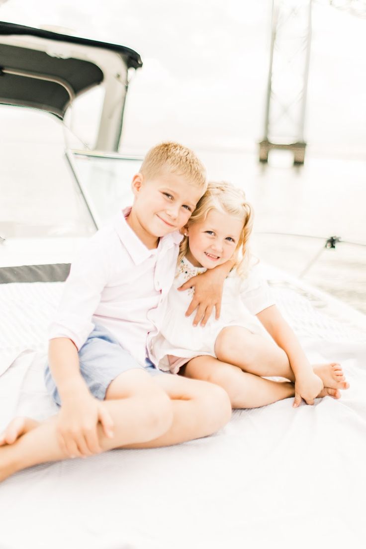 two young children sitting on the back of a boat