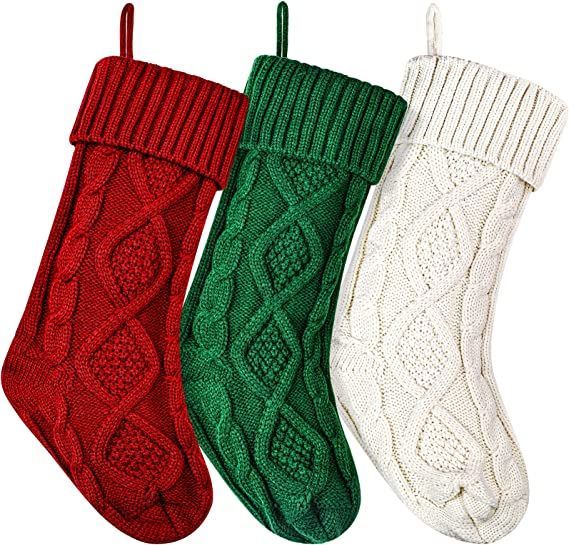 four christmas stockings hanging from hooks on a white wall with green, red and white knitted stocking