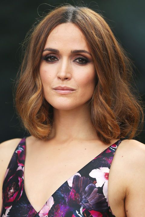 a woman with brown hair wearing a floral dress