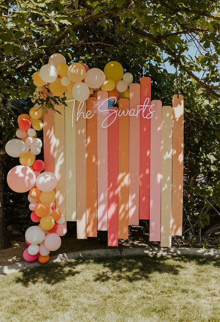 a sign with balloons attached to it that says the swart's in front of some trees